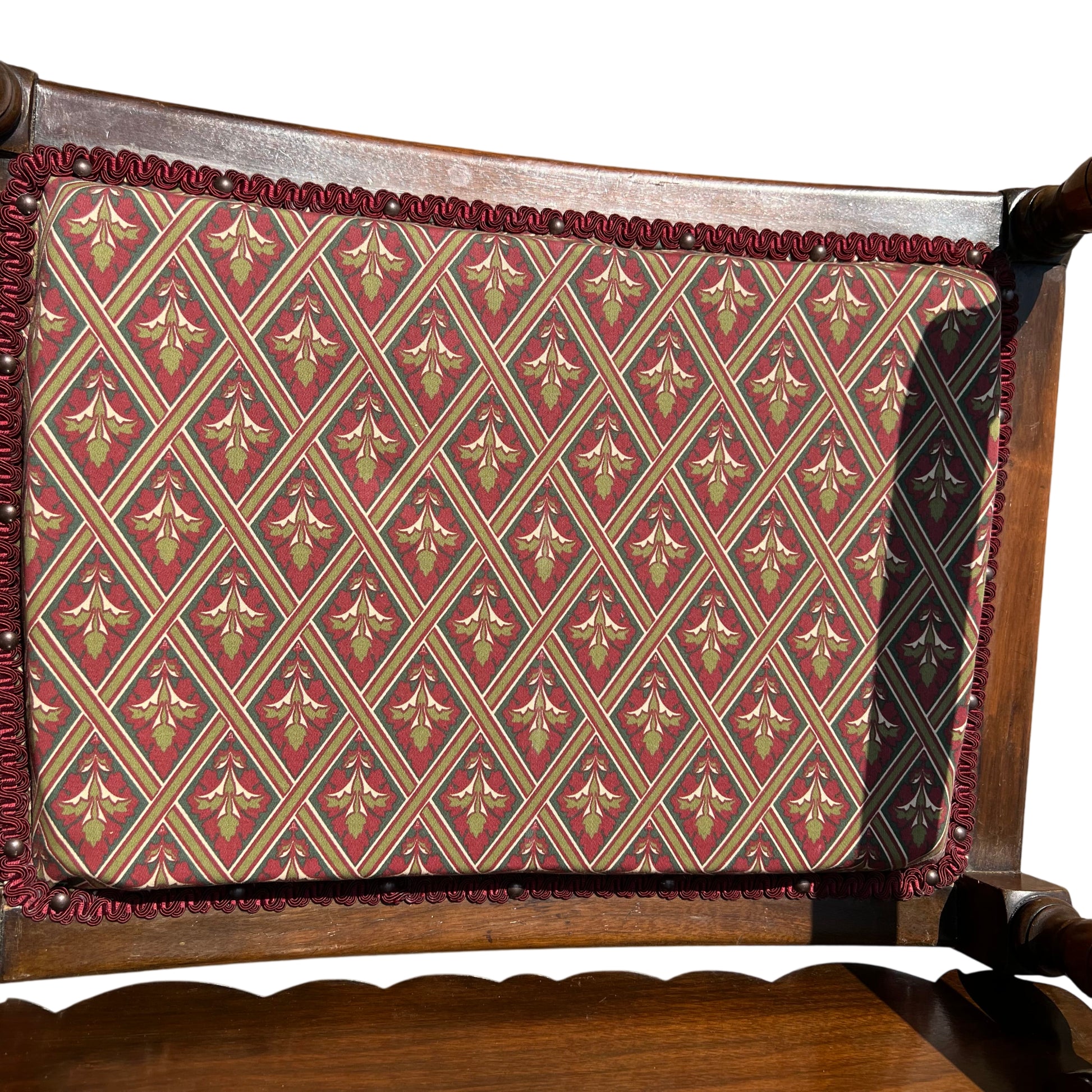 Close-up of scalloped top backboard on a vintage wooden armchair