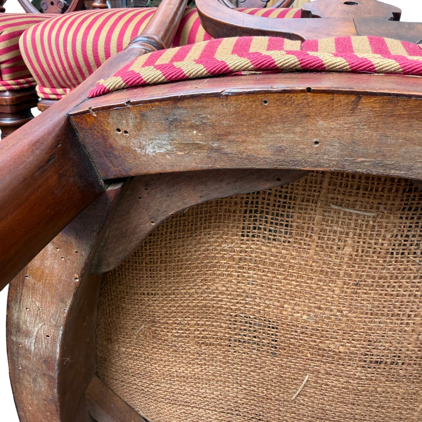 Detail of wood surface wear, scuffs and small chips visible on chair frame