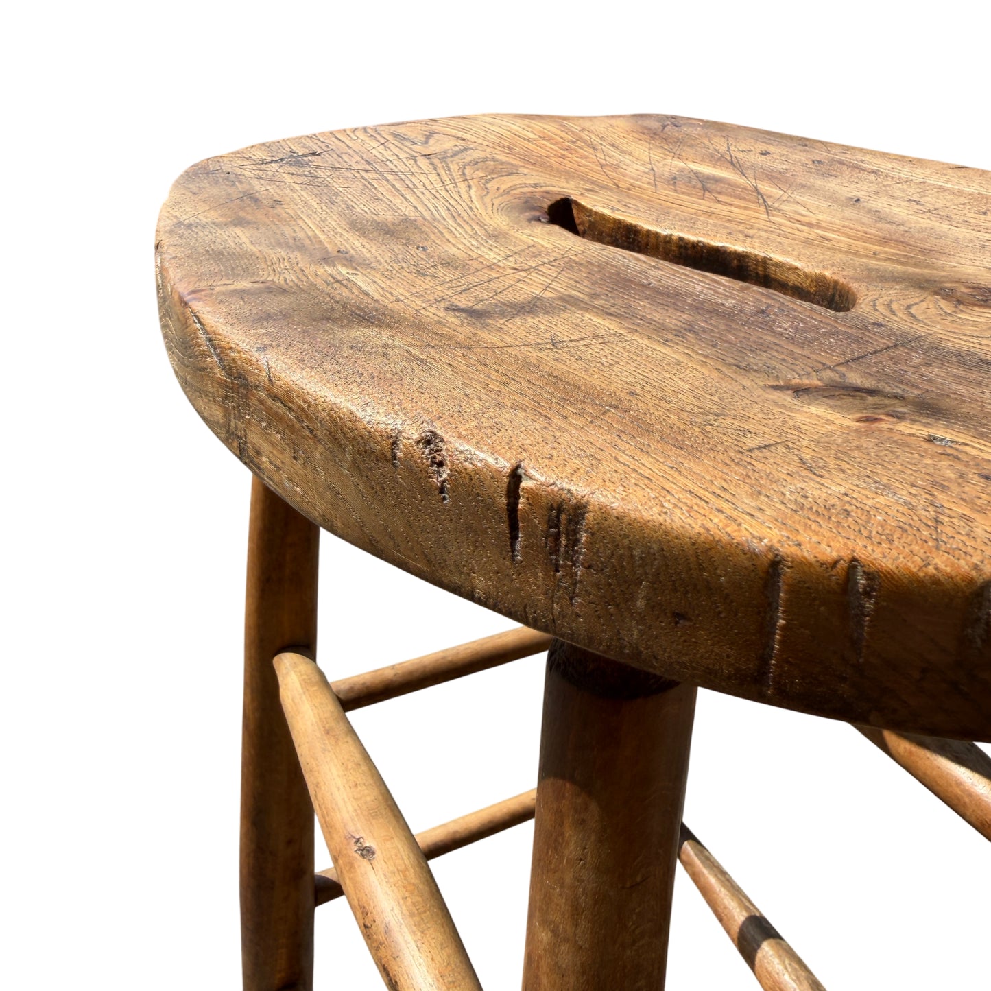 Edge detail of oak stool seat with small chip and worn finish