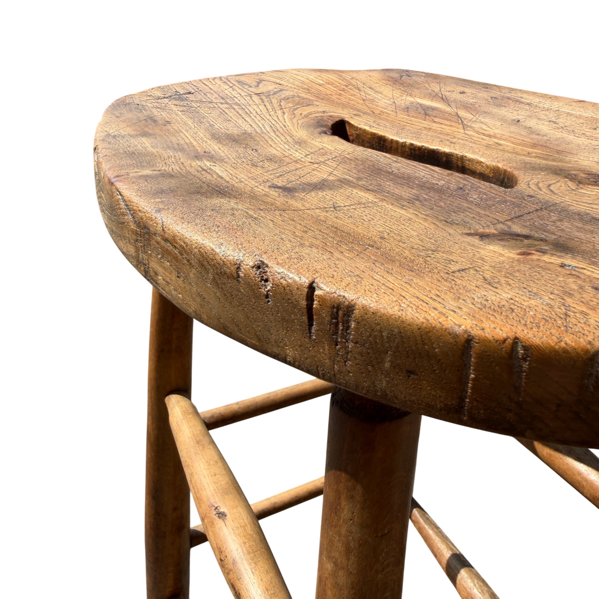 Edge detail of oak stool seat with small chip and worn finish
