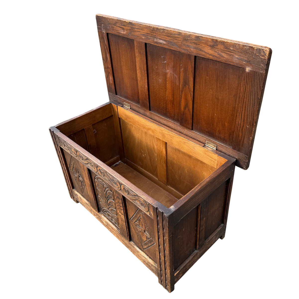 Side view of oak blanket chest showing vertical moulding and carved detail