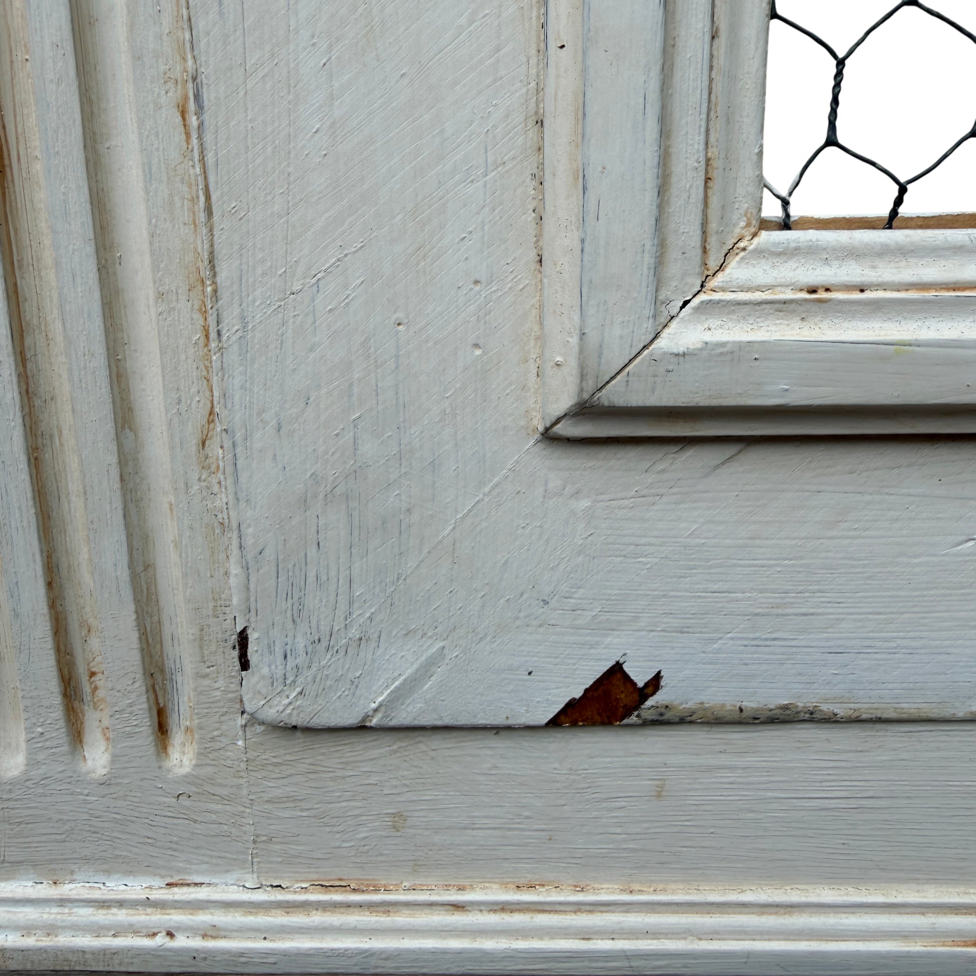 Lower section of painted display cabinet showing turned foot and paint wear at base
