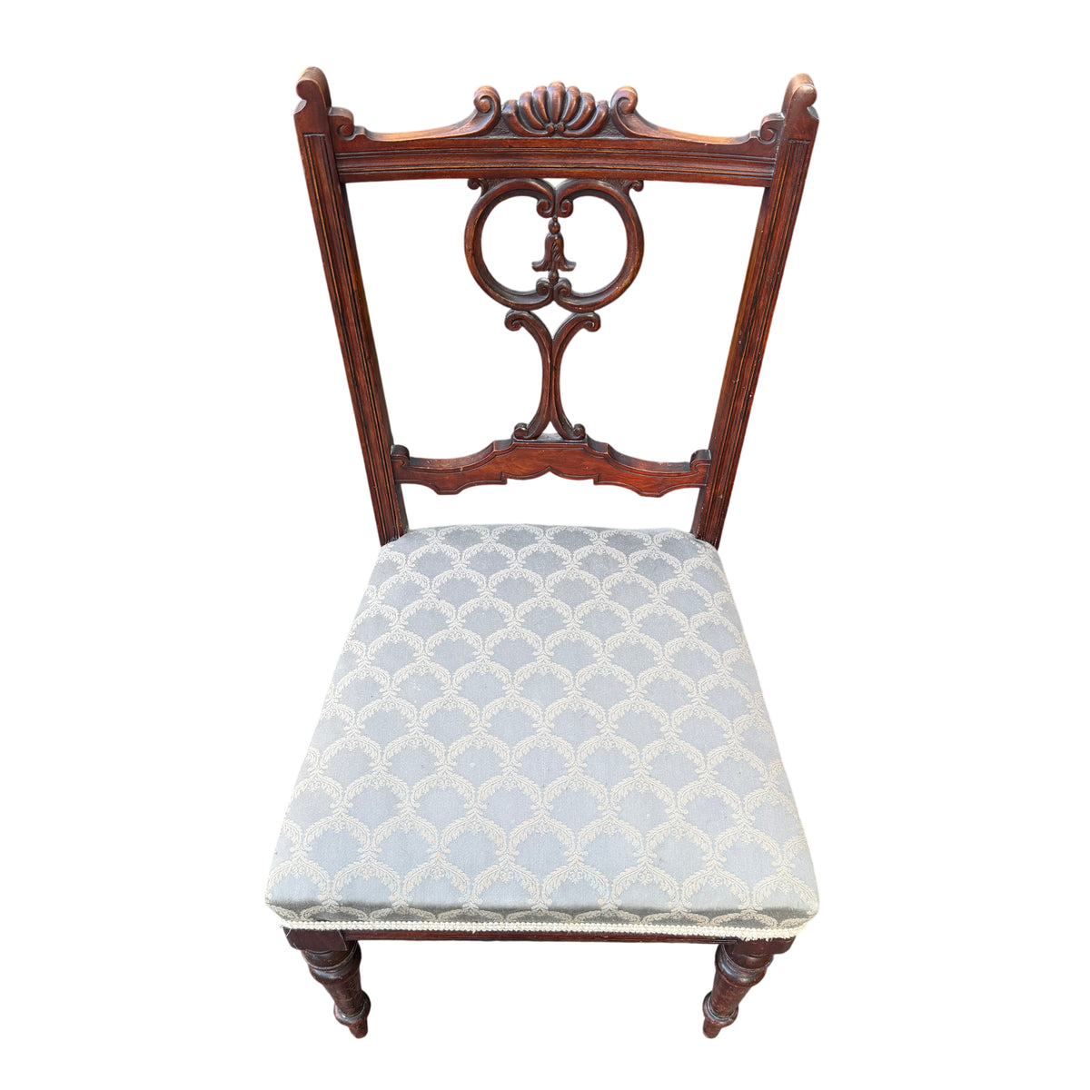 Side view of antique mahogany dining chair with turned front leg and upholstered seat