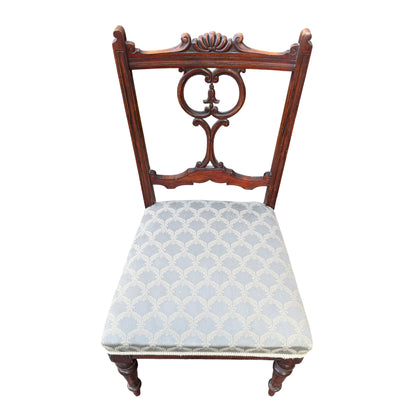 Side view of antique mahogany dining chair with turned front leg and upholstered seat