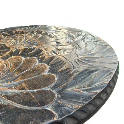 Detail of round carved floral top on a vintage hardwood side table