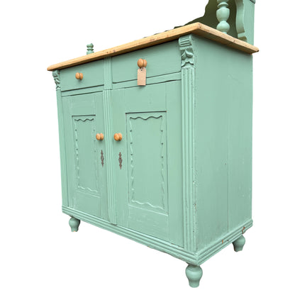 Green painted pine storage cabinet with wooden knobs and lower cupboard doors