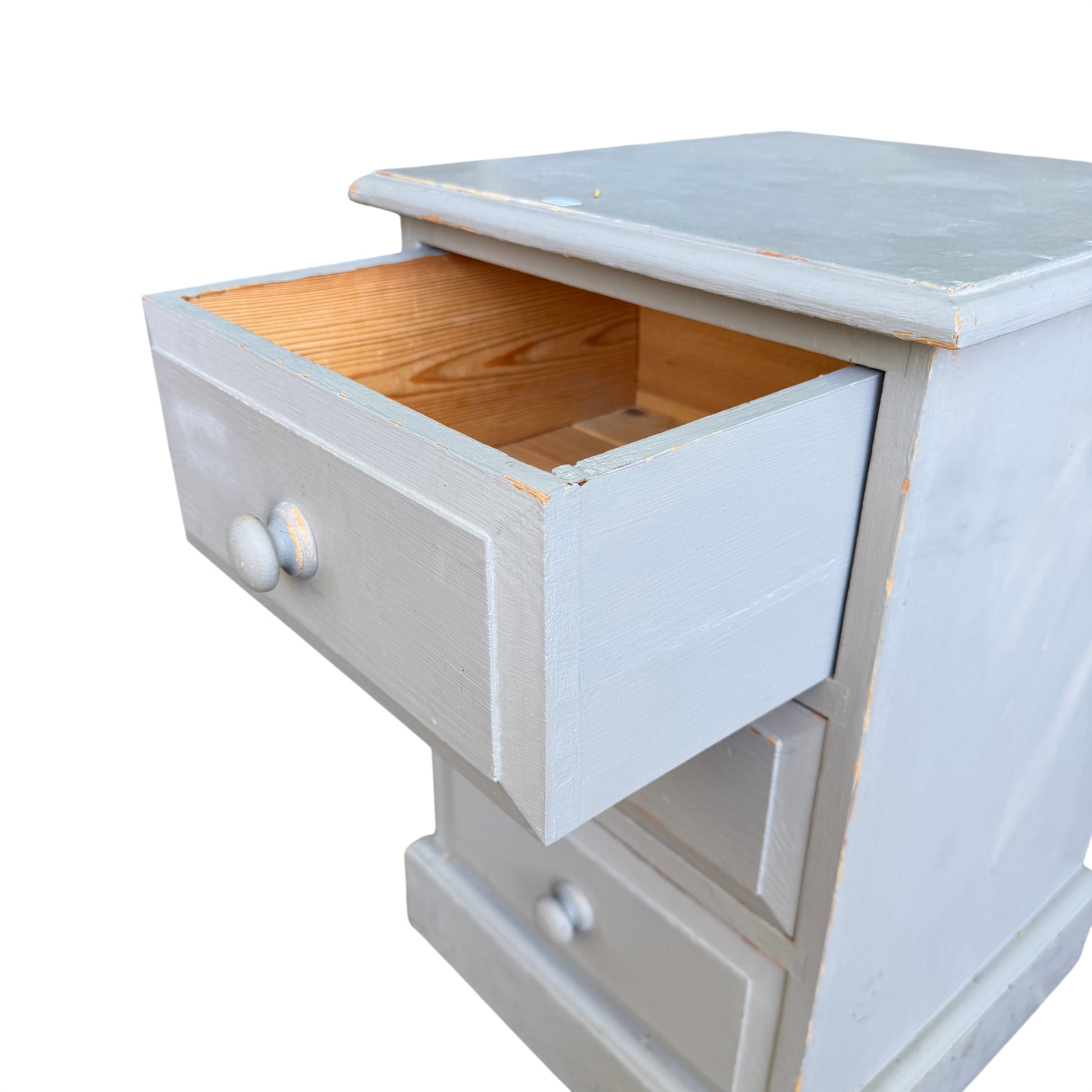 Close-up of top corner of painted pine chest showing paint wear and nicks