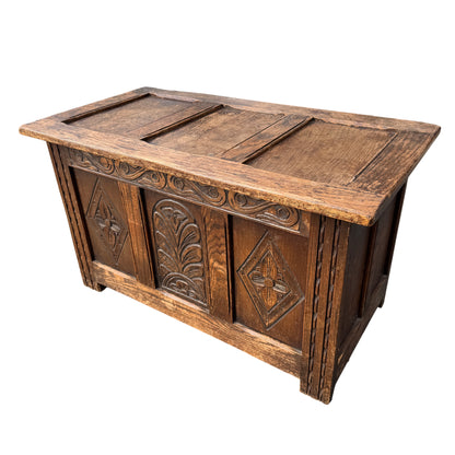 Front view of oak blanket chest with three carved panels in Arts & Crafts style