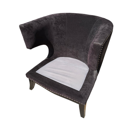 Detailed view of winged arm shape on a dark upholstered lounge chair