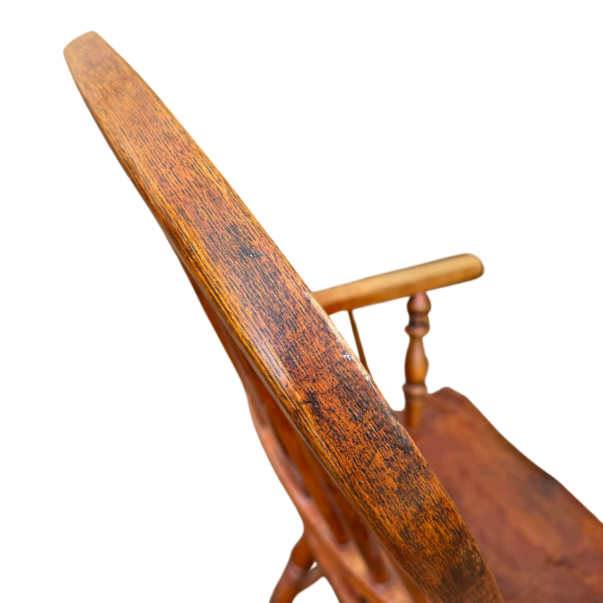 Three-quarter view of vintage oak armchair highlighting spindle back and carved splat
