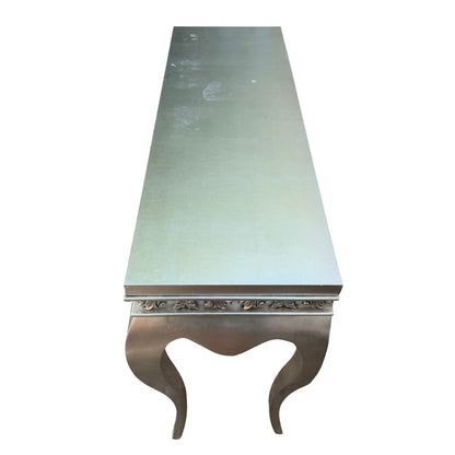 Angle view showing the table leg profile and silver painted finish on a console table