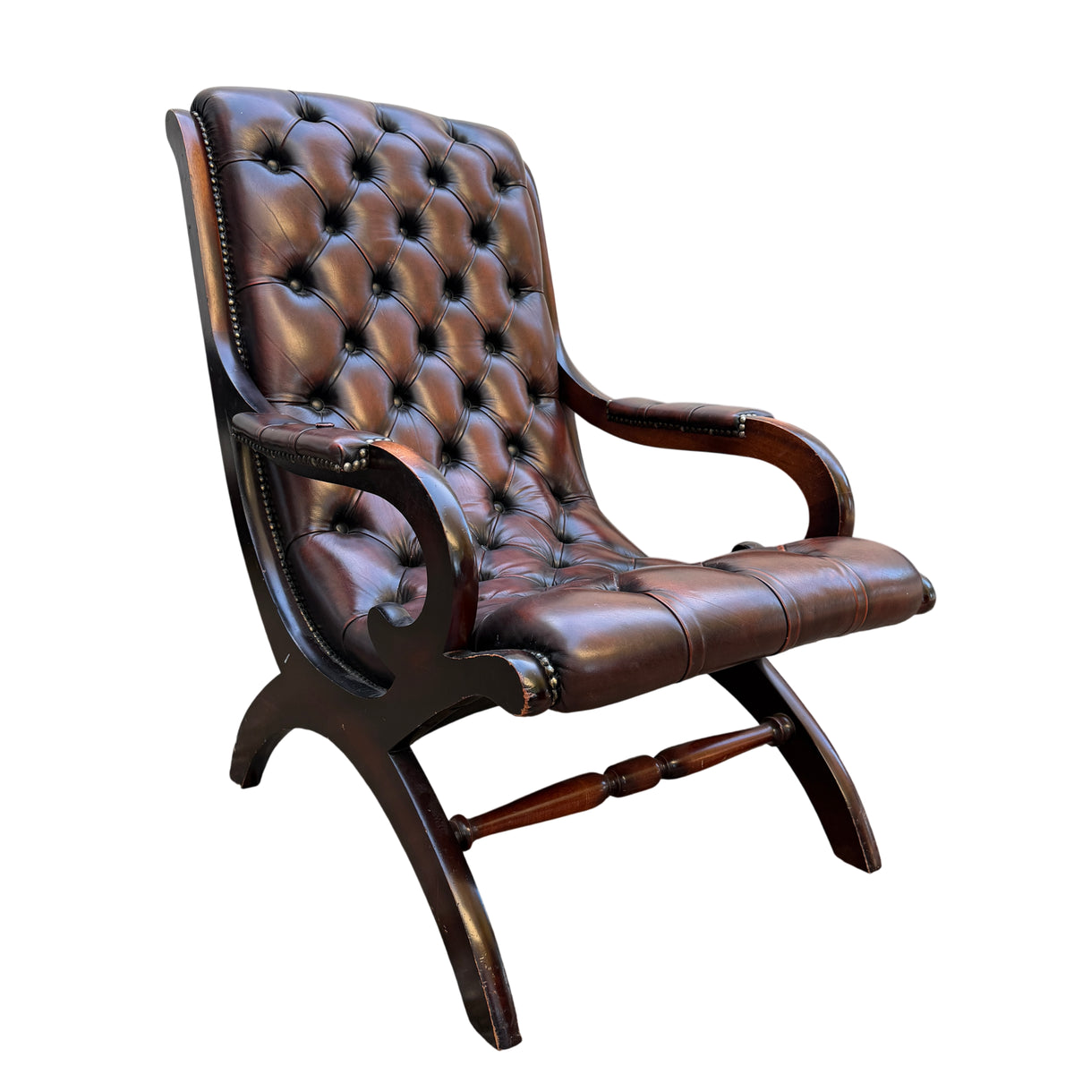 Button-tufted brown leather armchair with studded trim and wooden frame three-quarter view