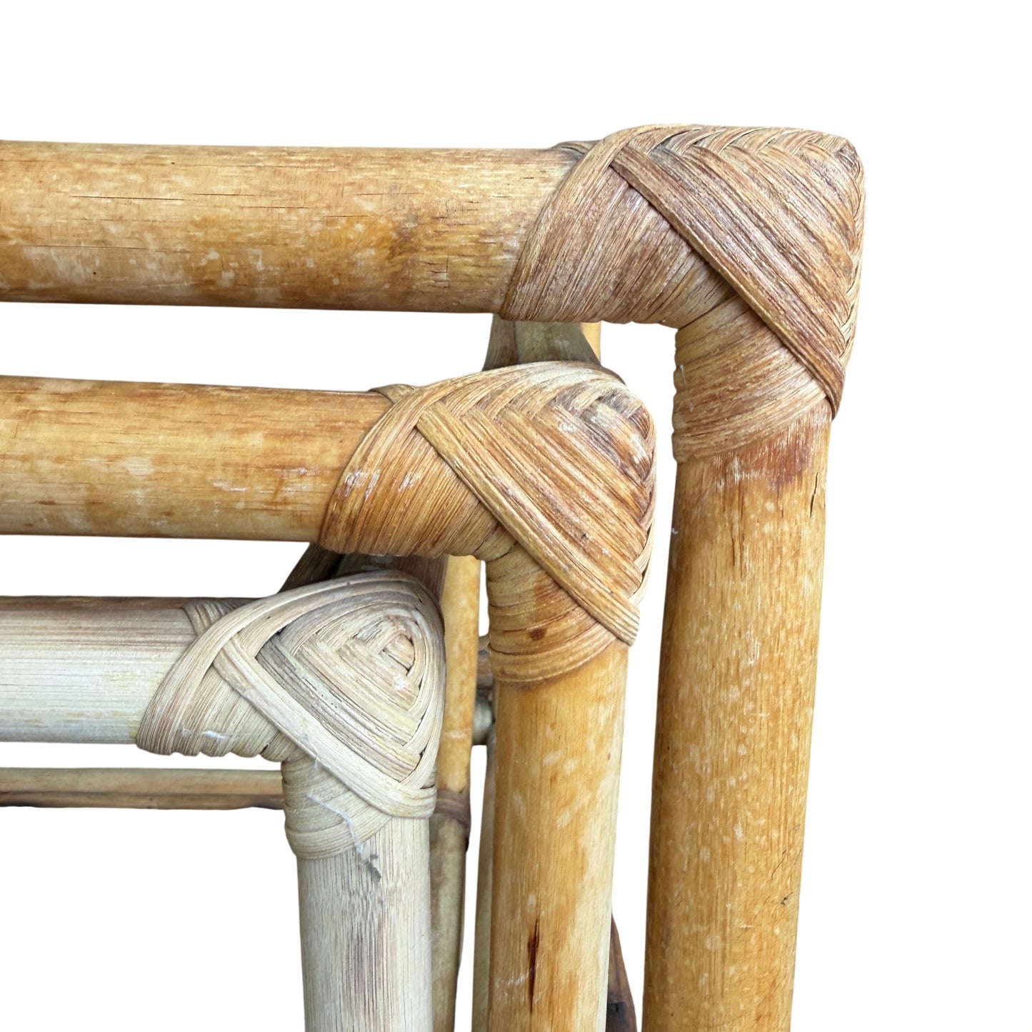 Stacked cane nesting tables showing upright frame construction and glass tops