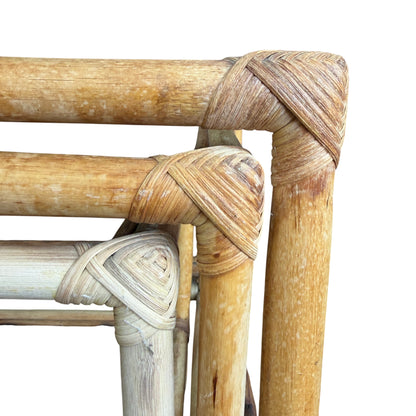 Stacked cane nesting tables showing upright frame construction and glass tops