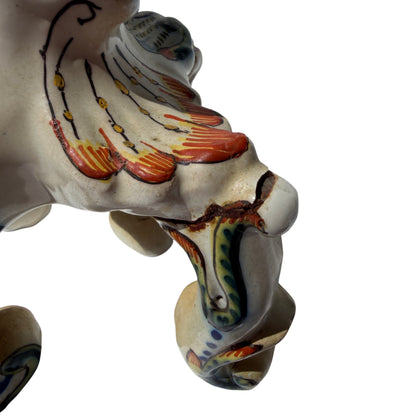 Close-up of painted blue and orange floral motifs on faience-style candlestick