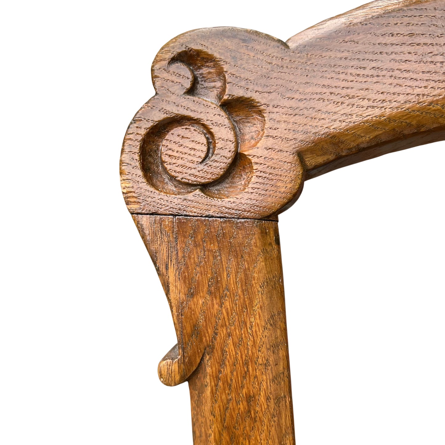 Three-quarter view of carved oak dining chair with upholstered seat