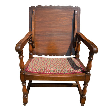 Traditional wooden armchair showing turned front legs and solid backboard