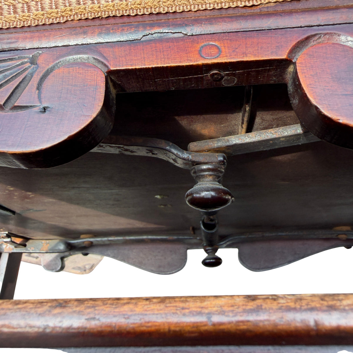 Close-up of carved scrolled arm showing wear to finish on Victorian stool