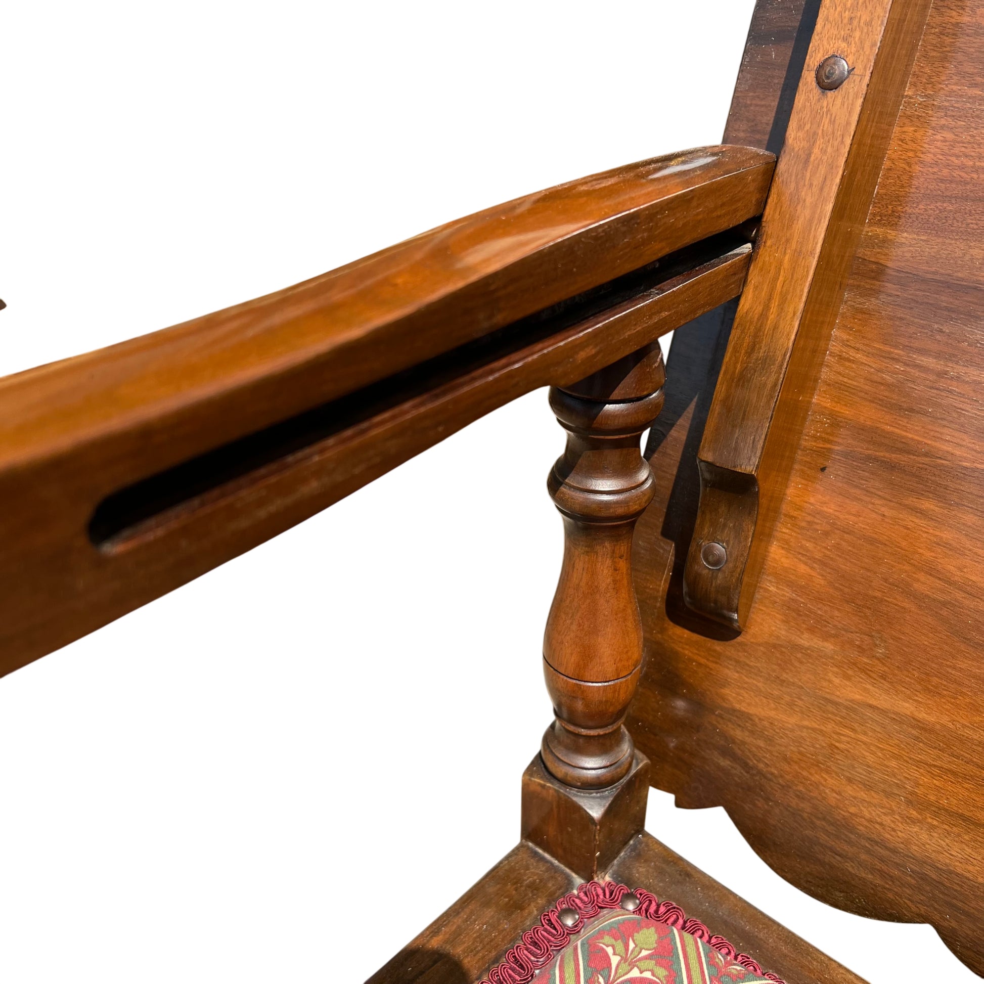 Front view of vintage armchair with patterned seat cushion and turned legs