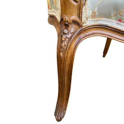 Carved wooden leg and frame detail of a vintage walnut bergère armchair