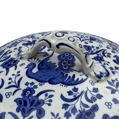 Close-up of tureen lid handle and blue painted detail on white ceramic