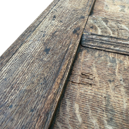 Side view of oak coffer with carved panel and carved border motifs