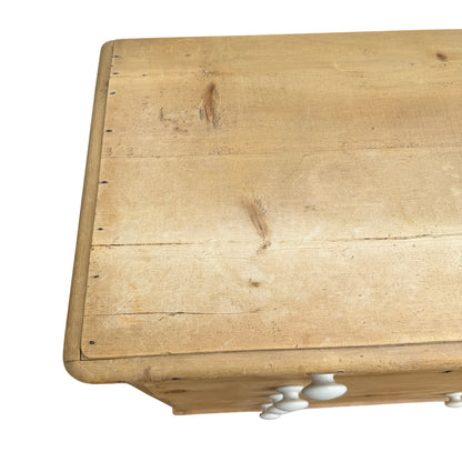 Detail of lower drawer and turned bun foot on pine chest of drawers