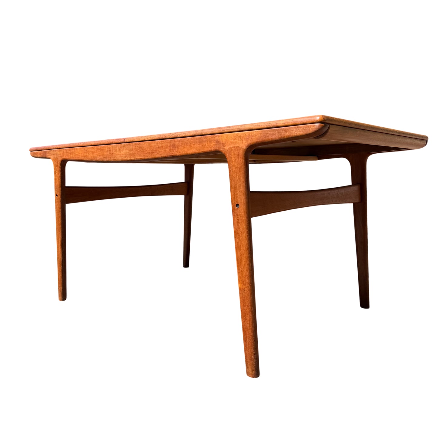 Mid Century Danish teak extending dining table by Mogens Kold shown outdoors, rectangular teak top and tapered legs