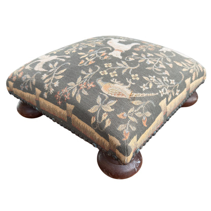 Vintage tapestry footstool with woven deer and bird motif, studded edging and turned bun feet
