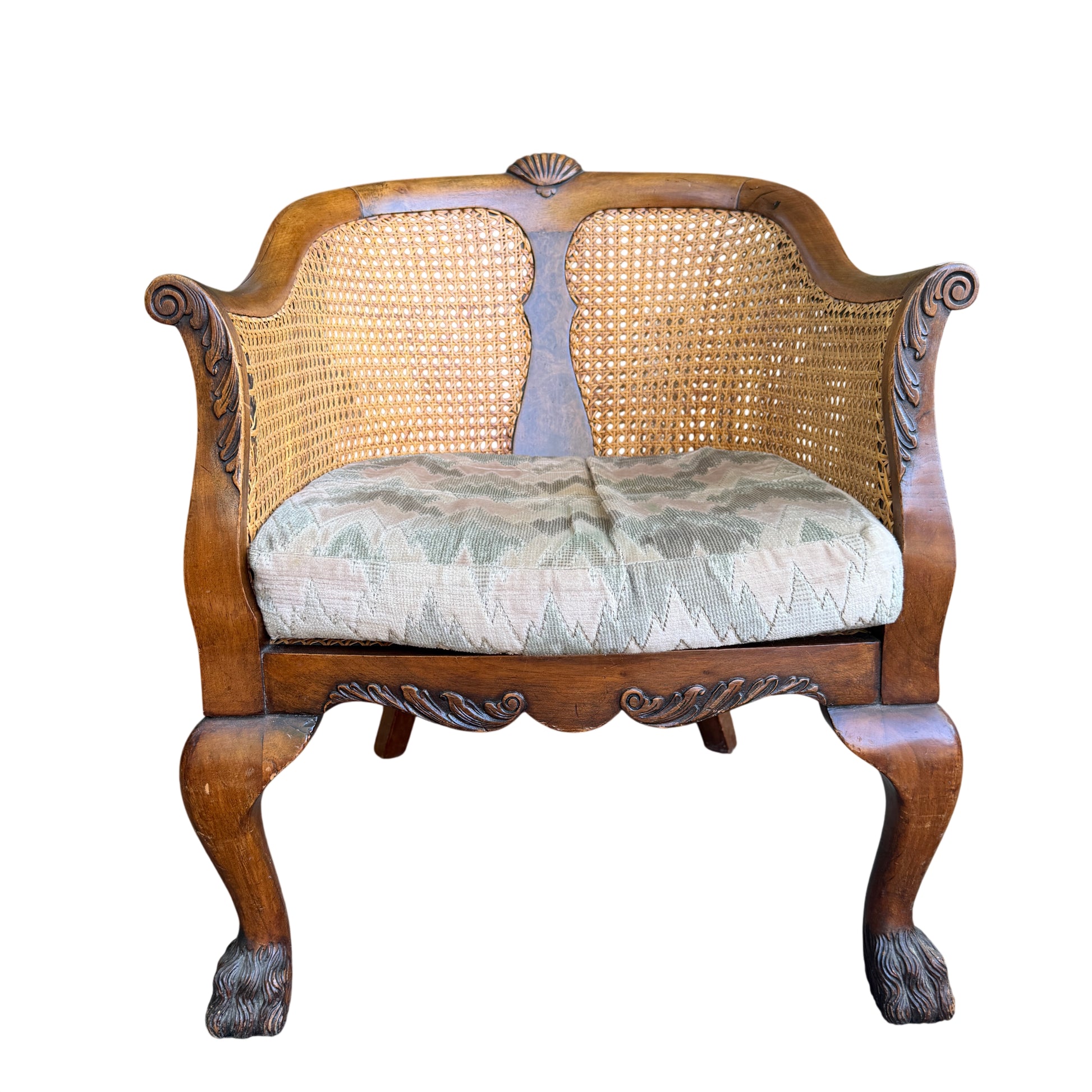 Close-up of carved top rail and woven cane back on vintage armchair