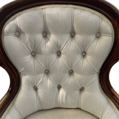 Side profile of upholstered armchair showing shaped wooden arm and back