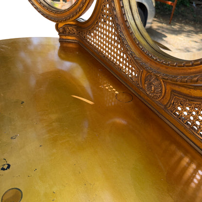Carved legs and stretcher of gold finish dressing table in outdoor setting