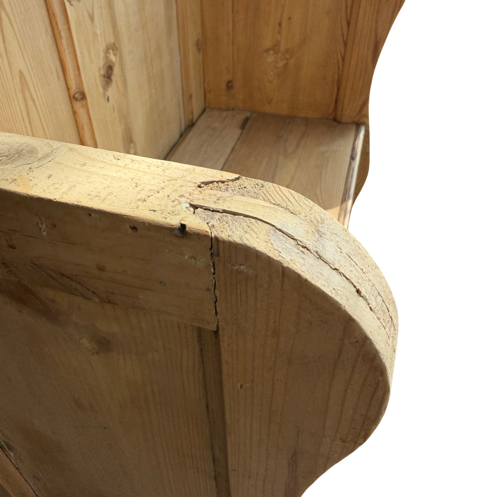 Angle view of pine settle showing side panel joints and aged patina