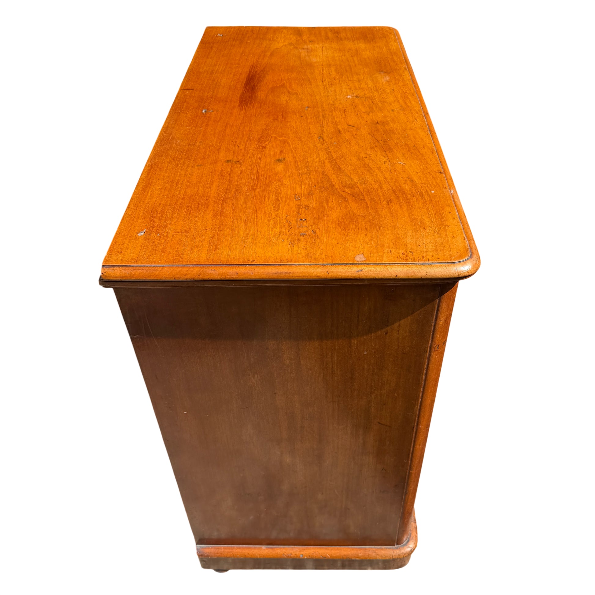 Three-quarter side view showing rounded front corners on pine chest of drawers