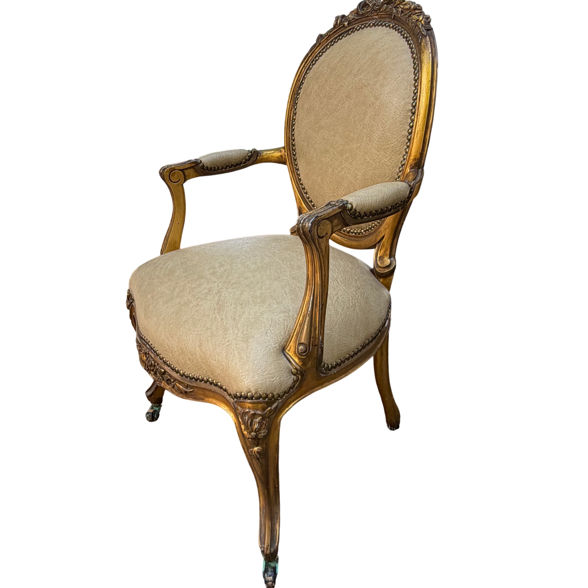 Top detail of carved ribbon and floral crest on the back of a gilt Louis-style armchair