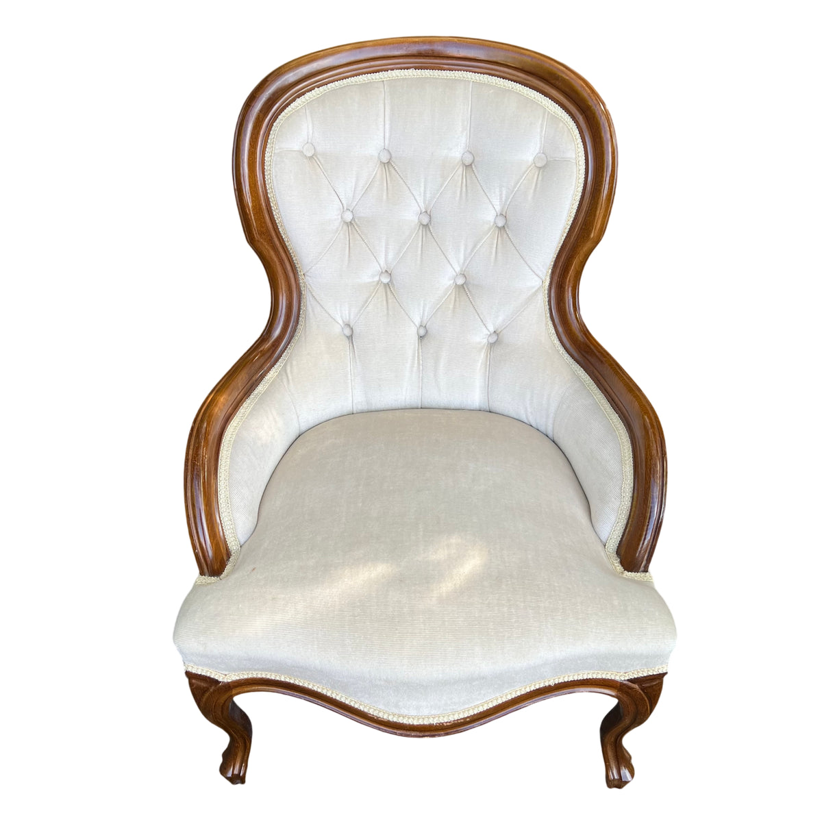 Front view Victorian button-tufted armchair with cream upholstery and wooden surround