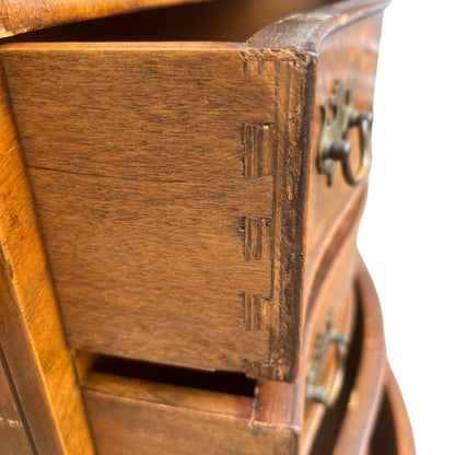 Close-up of brass drop handle and burr walnut veneer drawer front