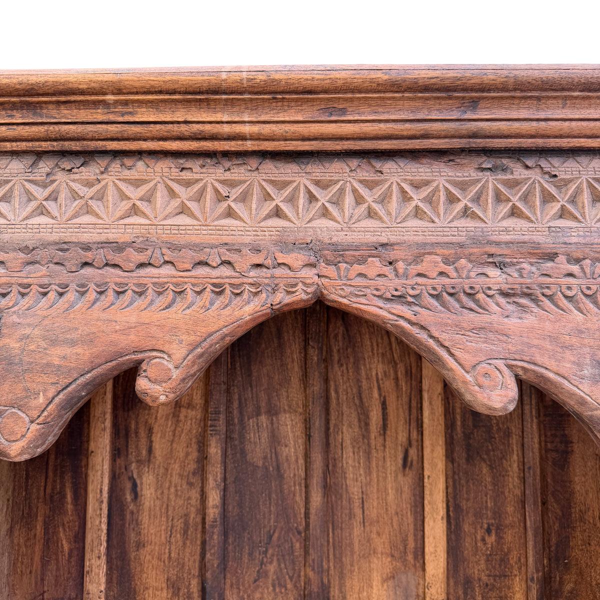 Hand carved foliate and geometric motifs on oak bookcase frieze