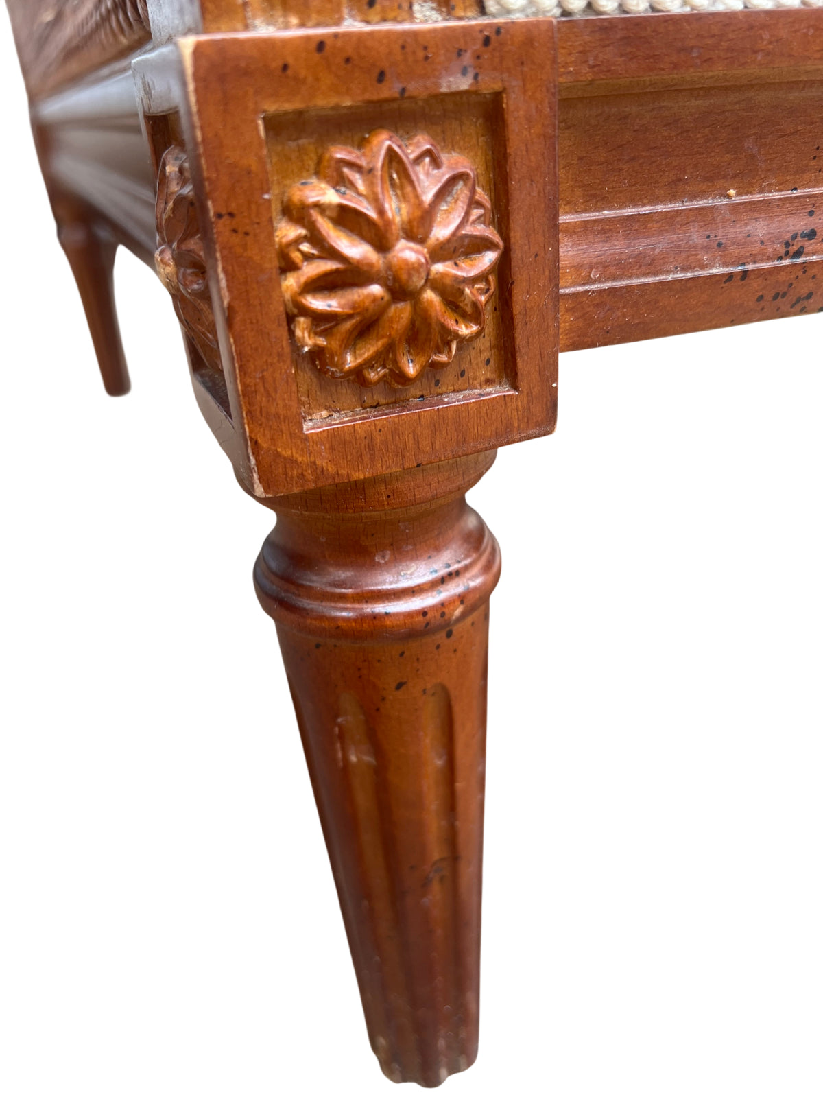 Detail of carved wooden scrolled arm on vintage cane armchair