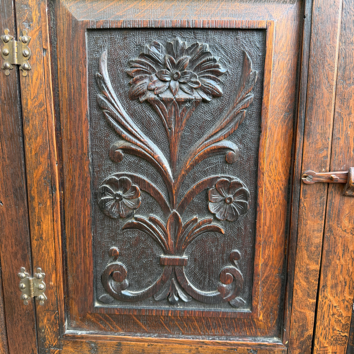 Top section of small oak corner cabinet showing pegged frame and wear