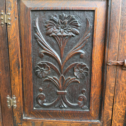 Top section of small oak corner cabinet showing pegged frame and wear