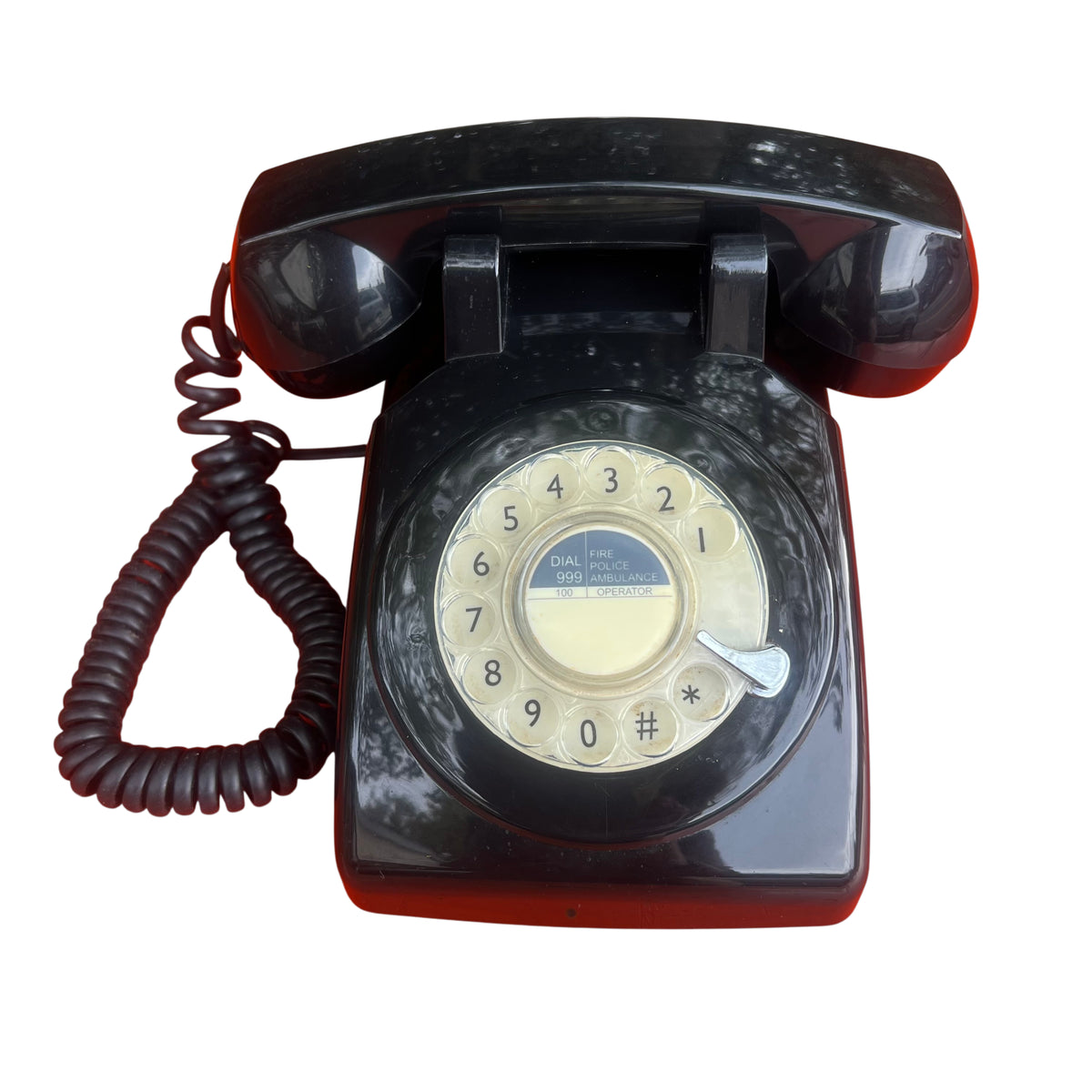 Vintage black Bakelite rotary telephone with rotary dial and coiled handset cord
