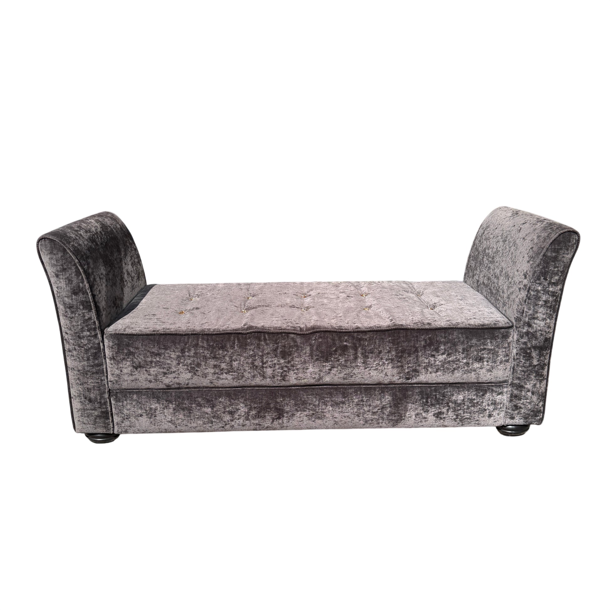 Side view of grey upholstered chaise longue showing curved arm and fabric texture