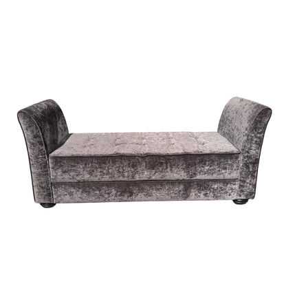 Side view of grey upholstered chaise longue showing curved arm and fabric texture