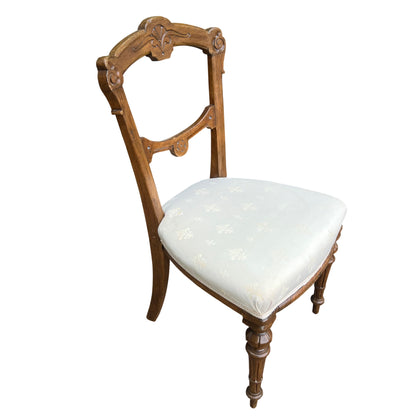 Close-up of carved back detail on oak dining chair showing scrollwork