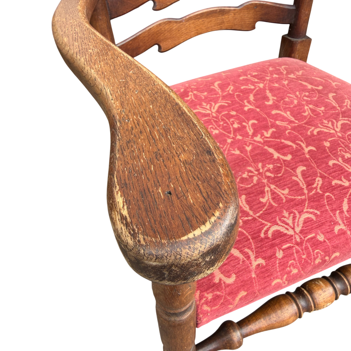 Red upholstered seat on a vintage oak dining chair with patterned fabric