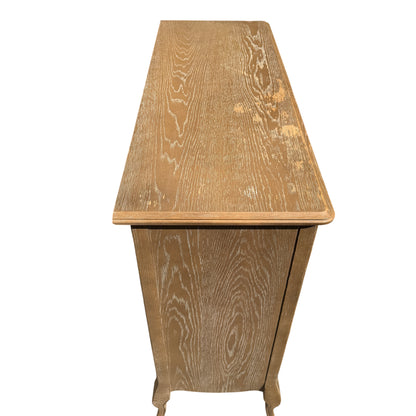 Full-height view of chest of drawers standing outside with visible grain finish and knobs