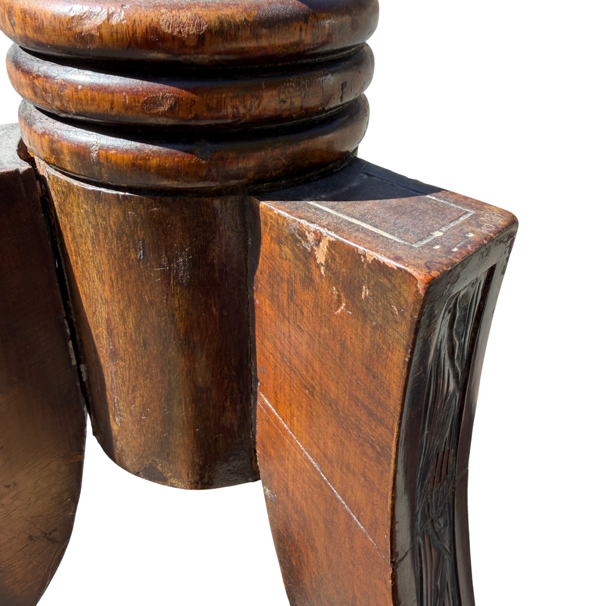 Foot detail showing rubbing and edge wear on carved base
