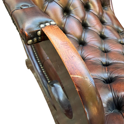 Vintage 1990s leather armchair with scuffed mahogany arms and studded edge