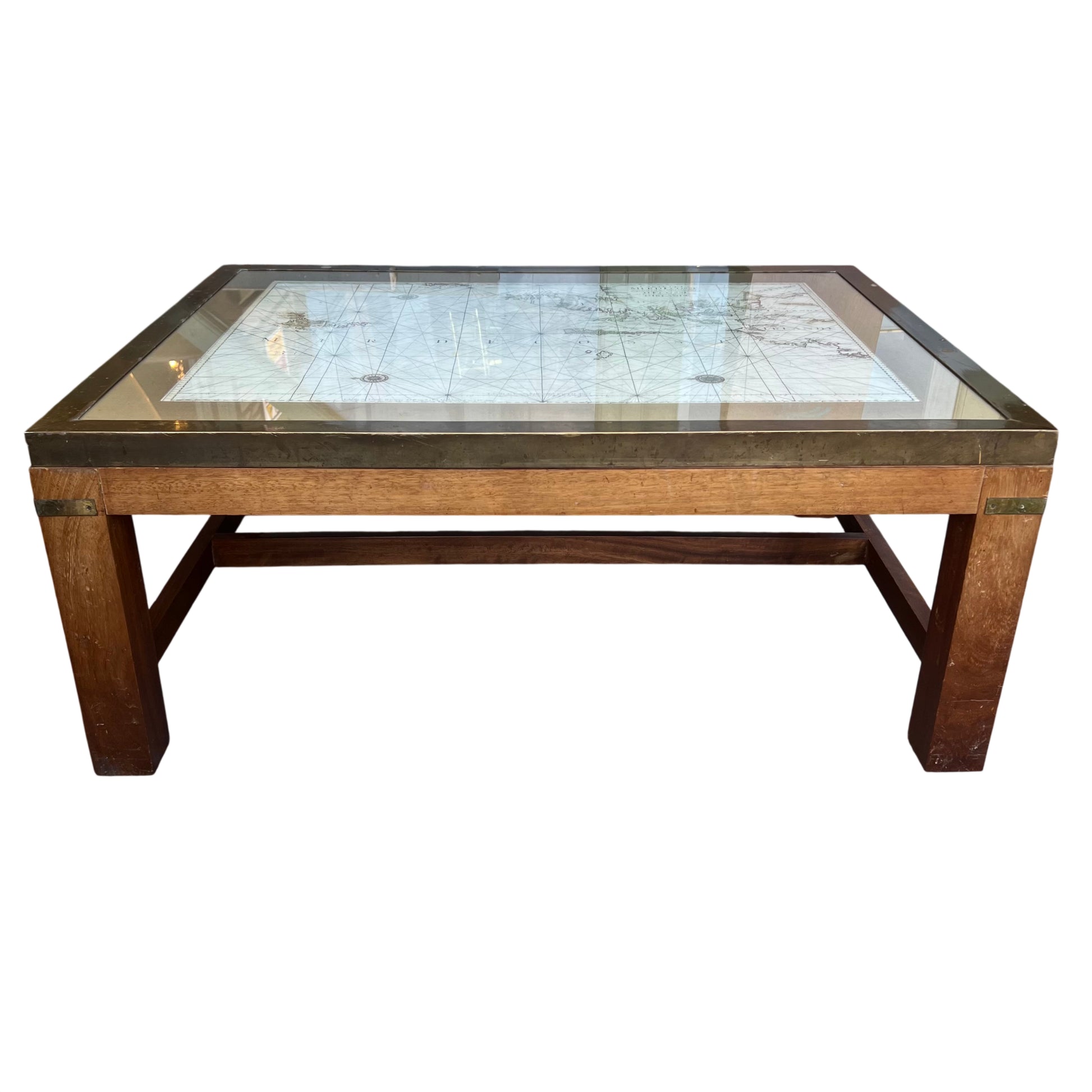 Low oak coffee table showing brass frame and clear glass top with map beneath